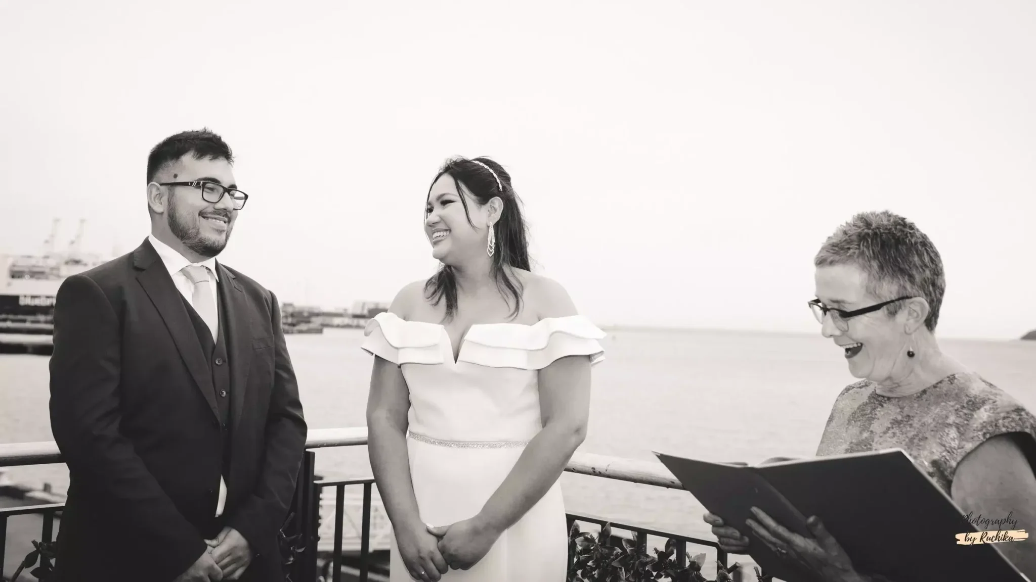 bride-and-groom-smiling-during-an-outdoor-wedding-ceremony-with-officiant-scaled